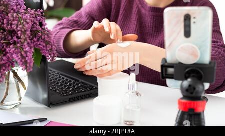 Blogger de beauté appliquer la crème sur les mains des femmes. Blogger faire de l'enregistrement de contenu vidéo en ligne, la diffusion en direct de l'examen sur les produits cosmétiques. Cosmologie Banque D'Images