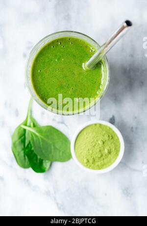 Vue en hauteur et vue rapprochée d'un smoothie aux épinards maison avec paille à boire en acier inoxydable Banque D'Images