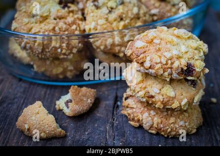 Biscuits et raisins de Cornflakes faits maison sur une vieille table en bois. Biscuits de céréales fraîchement cuits au four à flocons de maïs sur fond rustique. Mise au point sélective. Banque D'Images