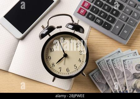 Composition avec horloge, argent et calculatrice sur fond de bois Banque D'Images