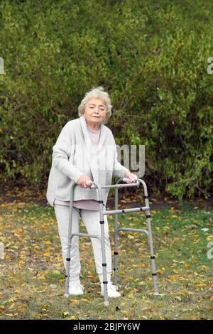 Femme âgée avec cadre de marche à l'extérieur Banque D'Images