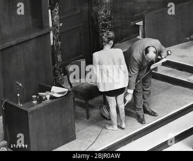 Survivant des camps de concentration Jadwiga Dzido montre sa jambe meurtrie au tribunal de Nuremberg, bien qu'expert médical explique la nature des procédures infligées à son RavensbrŸck dans le camp de concentration, le 22 novembre 1942. Photo prise le 20 décembre 1946. Banque D'Images