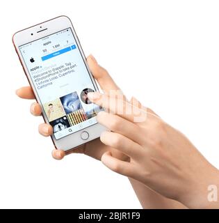 KIEV, UKRAINE - 17 OCTOBRE 2017: Femme tenant iPhone 7 plus Rouge avec une page Apple ouverte dans l'application Instagram à l'écran sur fond blanc Banque D'Images