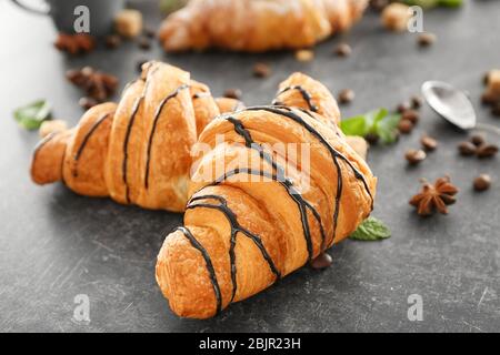 Délicieux croissants avec sirop de chocolat sur table Banque D'Images