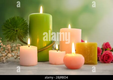 Cire bougies brûlant sur la table contre fond flou Banque D'Images