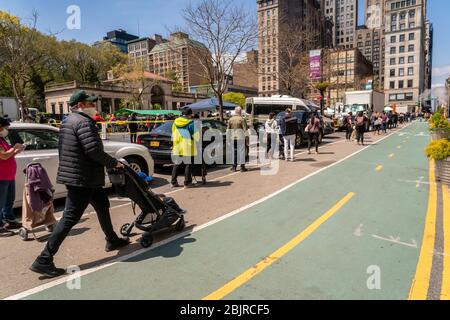 Les gens pratiquent des distanciation sociale en dehors du marché vert d'Union Square à New York car ils limitent le nombre de clients autorisés à entrer le samedi 25 avril 2020 les fournisseurs gèrent les marchandises pour les clients au lieu de leur permettre de se rassembler et de choisir leurs propres et la densité du marché est contrôlée. (© Richard B. Levine) Banque D'Images