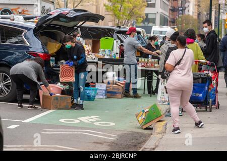 Les bénévoles évangéliques de Chelsea à New York distribuent de la nourriture le samedi 25 avril 2020. Avec 26 millions de personnes qui demandent des panessais alimentaires de chômage sont devenues un boulin de sauvetage pour beaucoup. (© Richard B. Levine) Banque D'Images