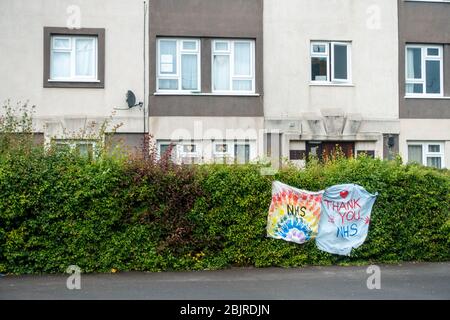 Des bannières maison attachées à une haie devant un bloc d'appartements offrent grâce au NHS. Banque D'Images