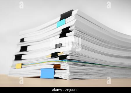 Pile de documents sur la table sur fond clair Banque D'Images