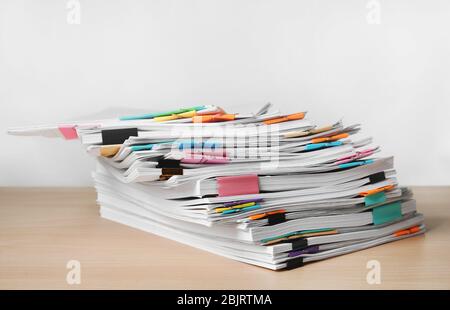 Pile de documents sur la table contre fond blanc Banque D'Images