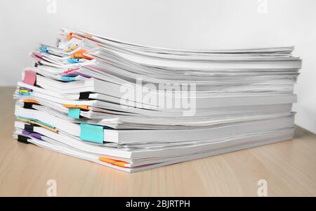 Pile de documents sur la table contre fond blanc Banque D'Images