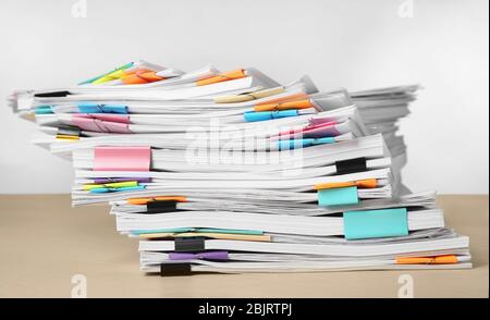 Pile de documents sur la table contre fond blanc Banque D'Images