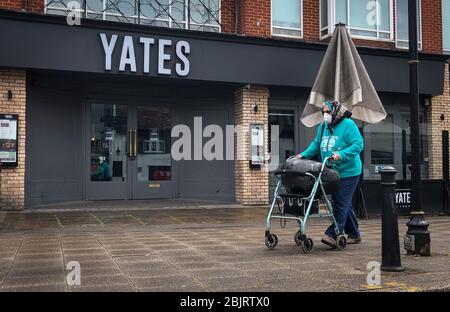 High Wycombe, Angleterre. Une dame masquée seule passe devant le pub fermé YATES pendant la pandémie COVID-19, comme le conseil du gouvernement britannique pour maintenir des distances sociales et réduire le temps en dehors dans High Wycombe le 30 avril 2020. Crédit: Images Prime Media / Alay Live News Banque D'Images