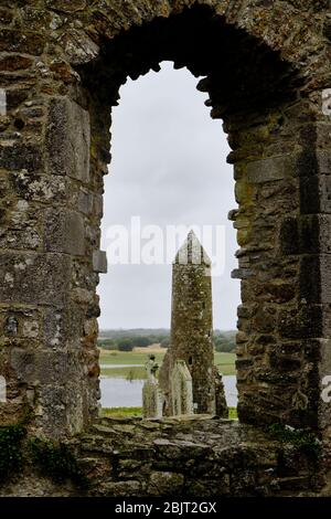 La Tour McCarthy vue par une fenêtre cathédrale dans le monastère médiéval de Clonmacnoise, pendant une journée d'été pluvieux. Il est situé dans le comté d'Offaly Banque D'Images