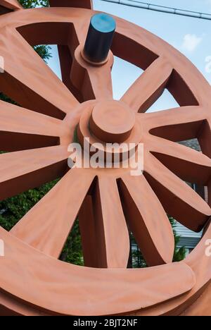 La sculpture de Fritz Church, la "Gateway", est la grande roue orange sur South Tacoma Way à Tacoma, Washington. Il repose sur deux pointes stylisées de chemin de fer. Banque D'Images