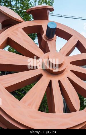 La sculpture de Fritz Church, la "Gateway", est la grande roue orange sur South Tacoma Way à Tacoma, Washington. Il repose sur deux pointes stylisées de chemin de fer. Banque D'Images