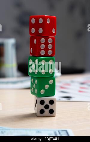 les dés sont à proximité d'une tourelle, de l'argent et des cartes de jeu, jouant sur une table en bois clair Banque D'Images