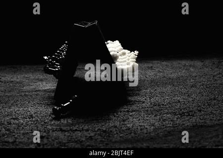 un chessboard se tient sur le côté un morceau noir a tombé la disposition des morceaux de pion blanc et noir sur le béton noir un fond sombre. espace de copie Banque D'Images