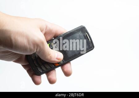 Ancien téléphone shabby à portée de main sur un isolant blanc de fond Banque D'Images