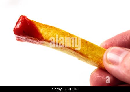 Frites avec ketchup dans les mains sur un blanc isolant de fond Banque D'Images