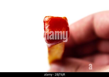 Frites avec ketchup dans les mains sur un blanc isolant de fond Banque D'Images