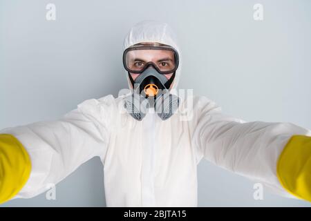 Gros plan photo de désinfectant spécialiste gars enregistrement vidéo de processus de travail faire selfies populaire blogger épidémique travailleur porter la combinaison de protection hazmat Banque D'Images