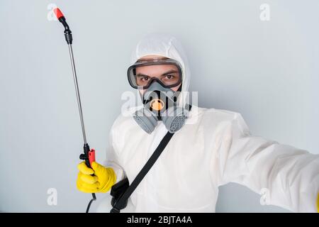 Gros plan photo de désinfectant spécialisé nettoyer les lieux publics montrer l'équipement suiveurs de la vidéo selfies blogger porter des vêtements de protection hazmat Banque D'Images