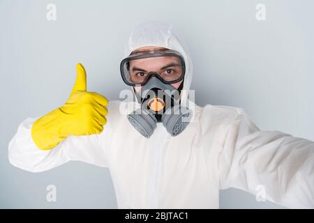 Gros plan photo de désinfectant spécialisé nettoyer les lieux publics montrer pouce vers le haut signer enregistrement processus de travail vidéo faire selfies blogger porter hazmat Banque D'Images