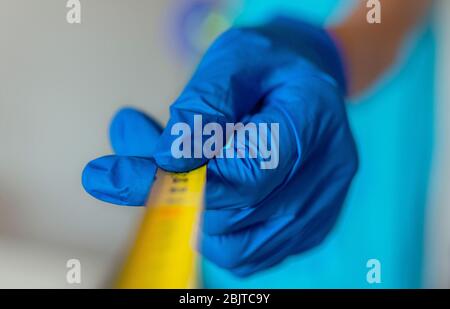 Photo conceptuelle de l'éloignement social pendant la crise du coronavirus. Focalisation sélective sur la bande jaune. Et les gants. Arrière-plan flou Banque D'Images