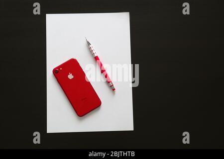 KIEV, UKRAINE - 24 NOVEMBRE 2017: IPhone 7 rouge avec stylo et papier sur table Banque D'Images