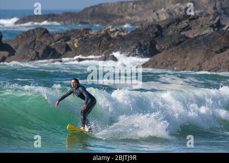 Une femelle à surfer une vague de Fistral Newquay en Cornouailles. Banque D'Images