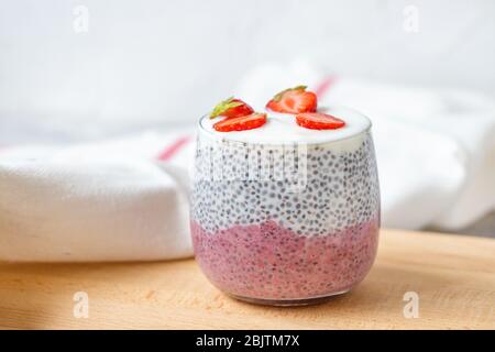 Pudding aux graines de Chia avec lait d'amande, yaourt, poudre de fruits de dragon de pitaya rose et dessert aux fraises dans un verre. Concept de supercuisine et de cuisine végétalienne Banque D'Images