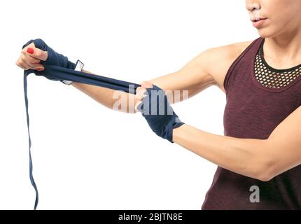 Boxer femme appliquant des poignets enveloppés sur fond blanc Banque D'Images