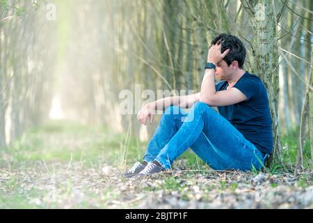 L'homme mécontent dans la forêt souffre de dépression et de frustration de la vie. Copier l'espace Banque D'Images