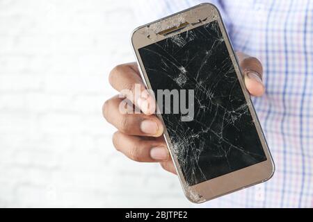 homme tenant son smartphone avec un écran cassé. Banque D'Images