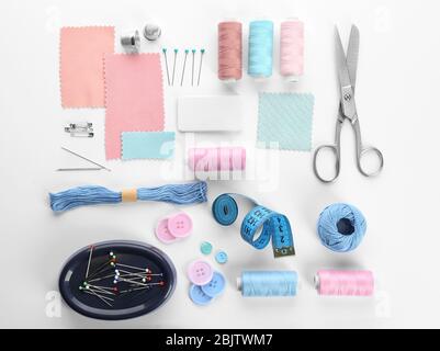 Composition avec fils à coudre et accessoires sur fond blanc, vue de dessus Banque D'Images