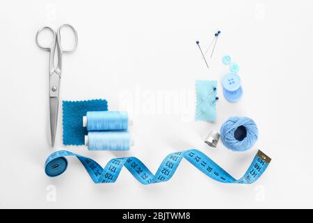 Composition avec fils à coudre et accessoires sur fond blanc, vue de dessus Banque D'Images