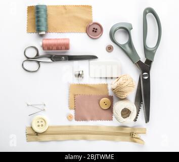 Composition avec fils à coudre et accessoires sur fond blanc, vue de dessus Banque D'Images