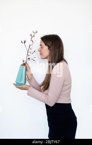 Portrait d'une femme caucasienne qui sent une plante Banque D'Images