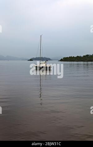 Yacht ancré sur le Loch Lomond, une journée misteuse, en Écosse Banque D'Images