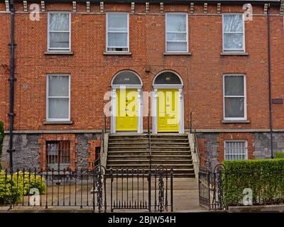 Des serres typiques en maçonnerie de Dublin avec des escaliers menant aux portes en jaune Banque D'Images