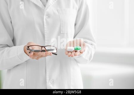 Médecin femme tenant la housse de lentilles de contact et les lunettes, clôture Banque D'Images