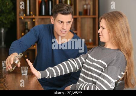 Jeune femme refusant de boire de l'alcool en bar Banque D'Images