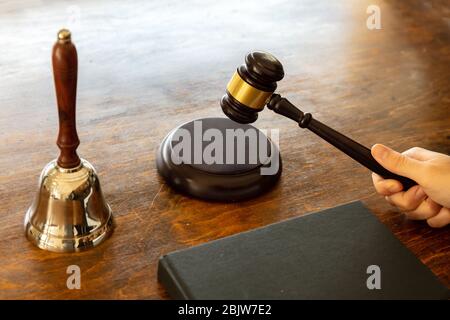 Juge tenant un gavel sur le fond de bureau de palais de justice en bois. Thème de la loi. Banque D'Images