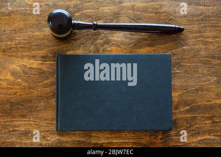 Thème de la loi. Juge gavel et un livre juridique noir blanc sur fond de bureau en bois, espace de copie. Vente aux enchères, table de tribunal Banque D'Images