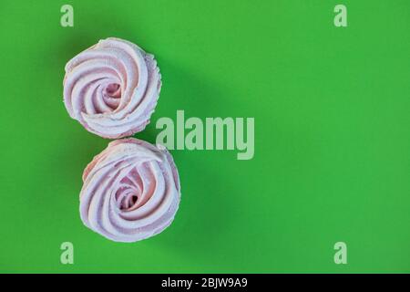 Gros plan dessert fraîchement cuit meringues marshmallow zephyr gâteau isolé sur fond vert. Dessert sucrerie. Banque D'Images