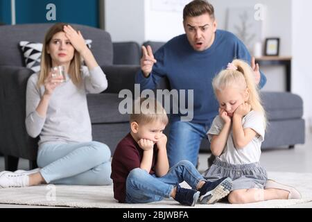 Les parents effarent leurs enfants à la maison. Conflit familial Banque D'Images