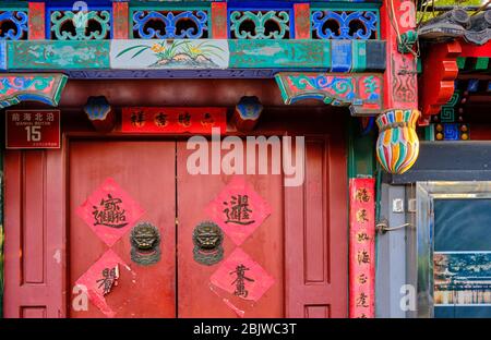 Beijing / Chine - 9 octobre 2018 : ancienne porte dans une ruelle traditionnelle de Pékin, décorée de personnages chinois symbolisant une bonne chance Banque D'Images