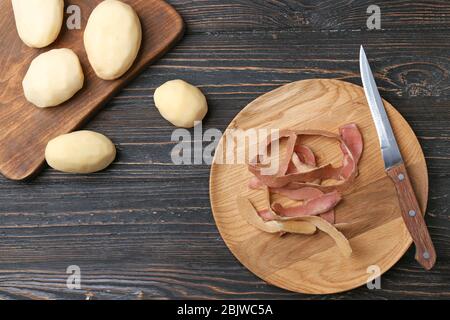 Composition avec pommes de terre pelées brutes sur table en bois Banque D'Images