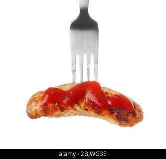 Fourchette avec de délicieux saucisses et sauce grillées sur fond blanc Banque D'Images